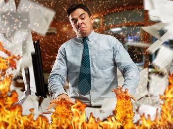 Angry businessman is burning papers in th office
