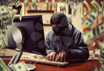 Hacker in mask stealing information and money at home