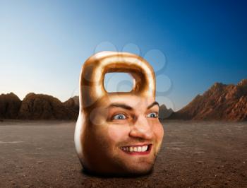Kettlebell with male face in mountains