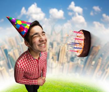 Happy smiling birthday boy with cake flying to his face