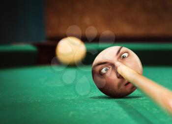 Billiard player aiming to ball with strange male face