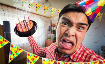 Crazy birthday boy with cake in his hand in decorated room