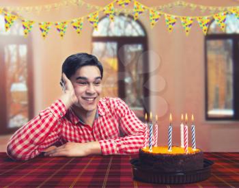 Happy birthday boy with cake in decorated room