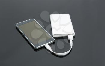 External power bank connected with a smartphone on the table