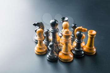 Set of chess figures on the table over black
