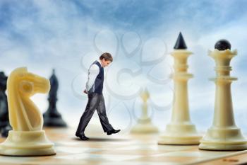Businessman is walking on the chess board thinking