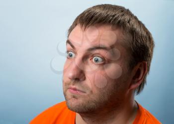 Portrait of surprised man wearing an orange T-shirt
