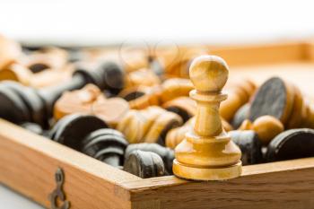 A wooden pawn on the chess box close up