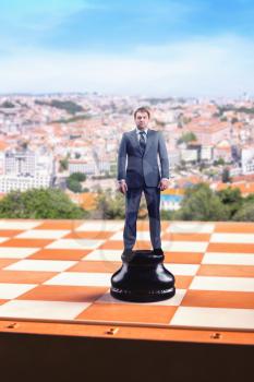 Businessman standing on the chess board like a figure