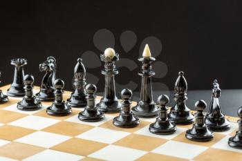 Black chess figures on the board ready to fight