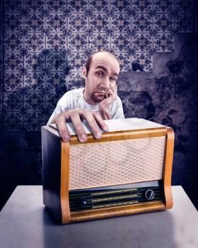 Sad man with vintage radio on the table