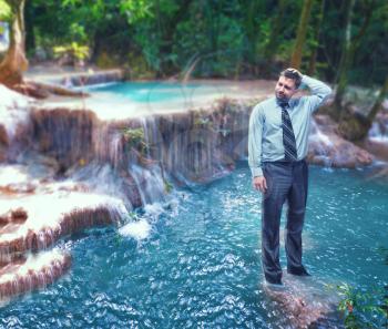 Troubled businessman standing in the waterfall