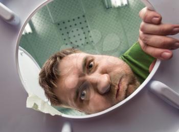 Man ready to puke in the bathroom in the toilet bowl