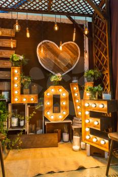 Romantic room with garland with lights and wooden letters of love 