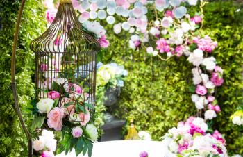 Spring garden with roses in decorative cage