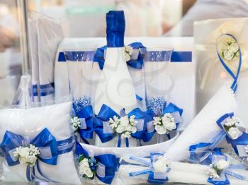 Beautiful blue festive set of glasses, candles and wine with ribbons