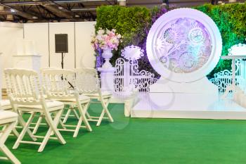 Wedding hall outside with a big clock, flowers and chairs