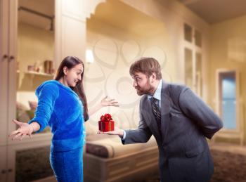 Businessman giving a gift to his wife, woman is surprised
