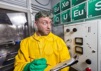 Man in the lab making notes from the control panel while cooking meth