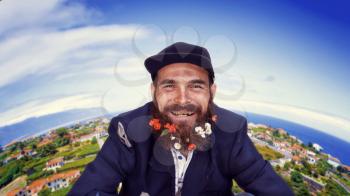 Bearded vagrant smiling with town on the background