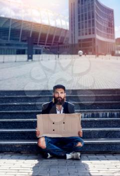 Homeless sitting with pieces of cardboard at the steps