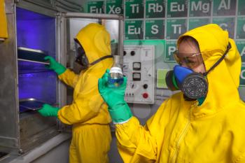 Man and woman in protective suits cooking methamphetamine in the lab