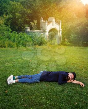 Homeless man sleeping on the green lawn