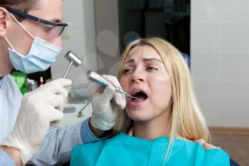 Portrait of young woman seeing a dentist, woman is experiencing pain