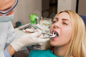 Young dentist treating woman in the office