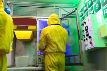 Man and woman in protective suits cooking meth in the lab