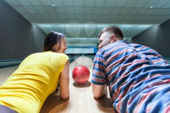 Couple lying on the floor in bowling closeup