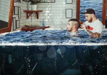Young man having hair dress in flooded barbershop, barber working with hair clipper
