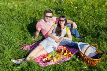 Young couple having picnic on the meadow