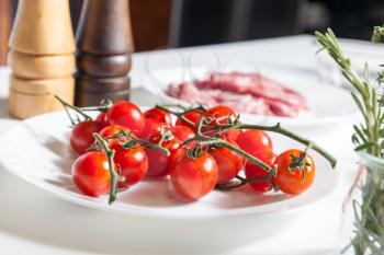 Close up of different ingredients on the table, cherry tomatoes in the foreground