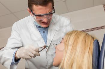 Dentist works with woman holding instruments