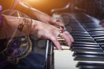 Close up of woman's hands playing the piano