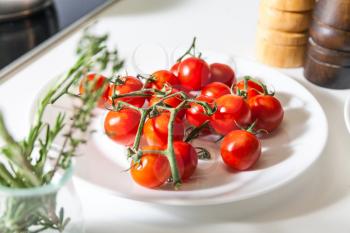Close up of different ingredients on the table, cherry tomatoes in the foreground