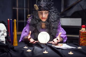 Sorceress looking at crystal ball in her room