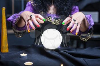 Close up of sorceress working with crystal ball in her room