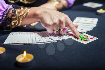 Close up of sorceress telling fortunes using cards