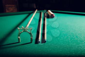 Billiard balls and pool sticks on the green table