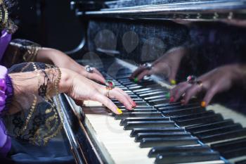 Close up of woman's hands playing the piano