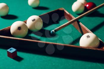 Billiard items on the table: balls, chalk, stick and triangle