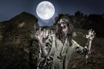 Scary zombie girl near the abandoned house. Horror. Halloween