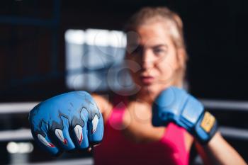Portrait of young woman boxing, gloved are focused