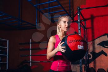 Young girl exercising with med ball in the gym