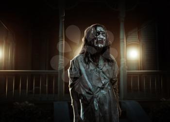 Zombie girl near the abandoned house. Horror. Halloween