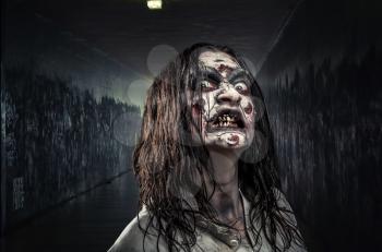Portrait of the horror zombie woman with bloody face