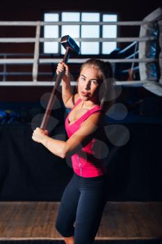 Woman exercising with hammer and a big wheel