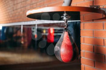 Black and red punching bag. Sport gym on the background. Boxing theme. Box equipment.
